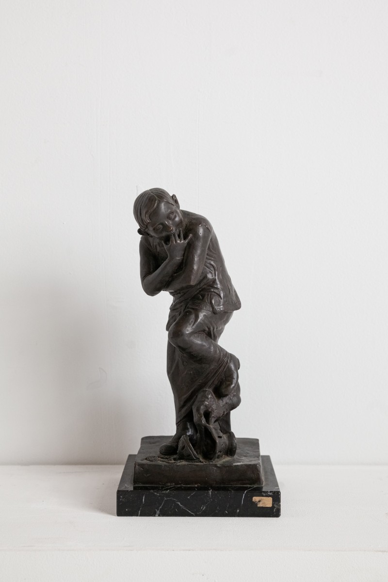 Bronze child figure on black marble base